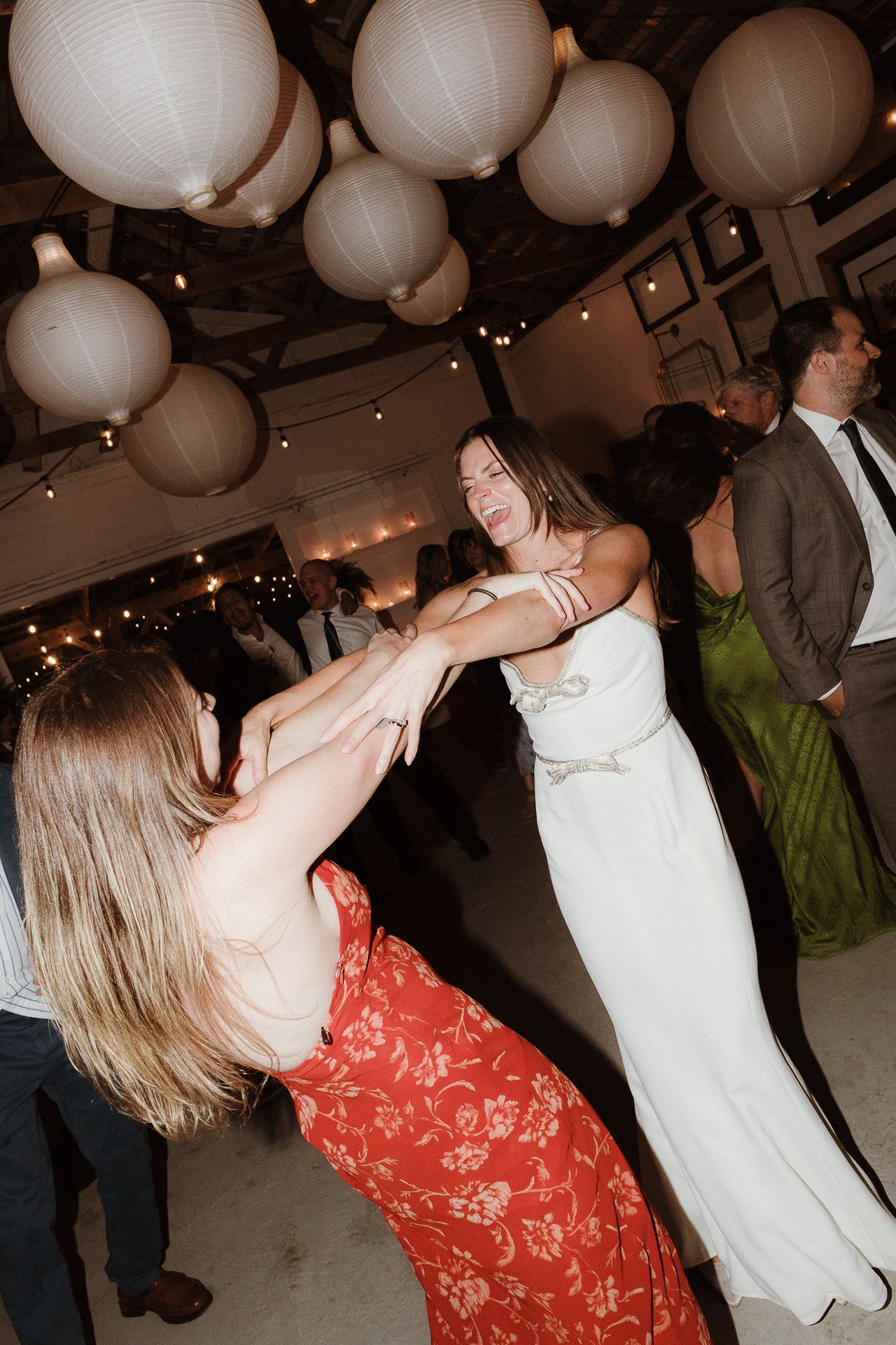 Guests dancing under lanterns at a summer M and D Farm wedding reception
