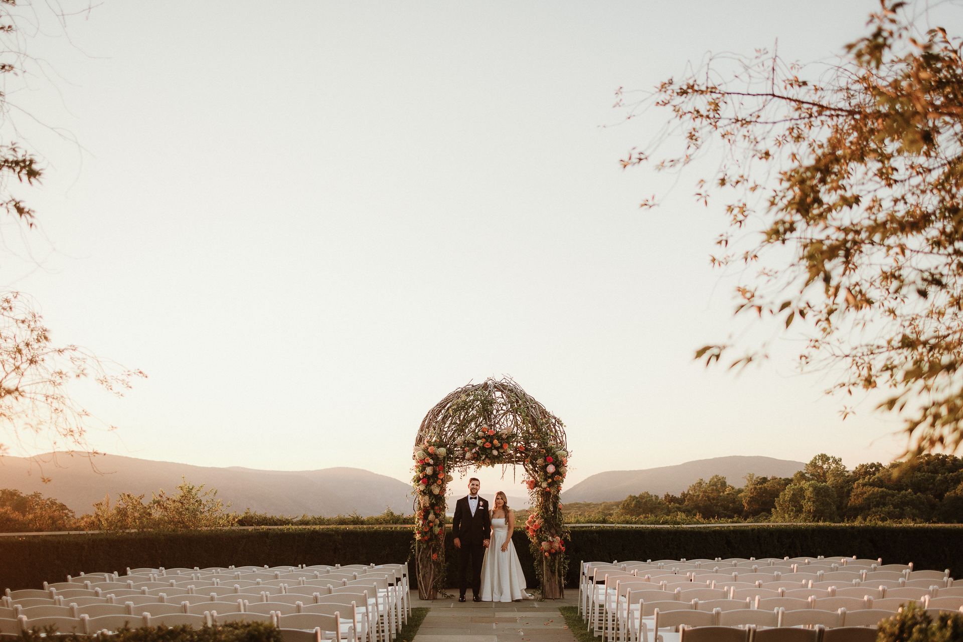 Outdoor ceremony under a floral arch with mountain views at a Garrison wedding in the Hudson Valley