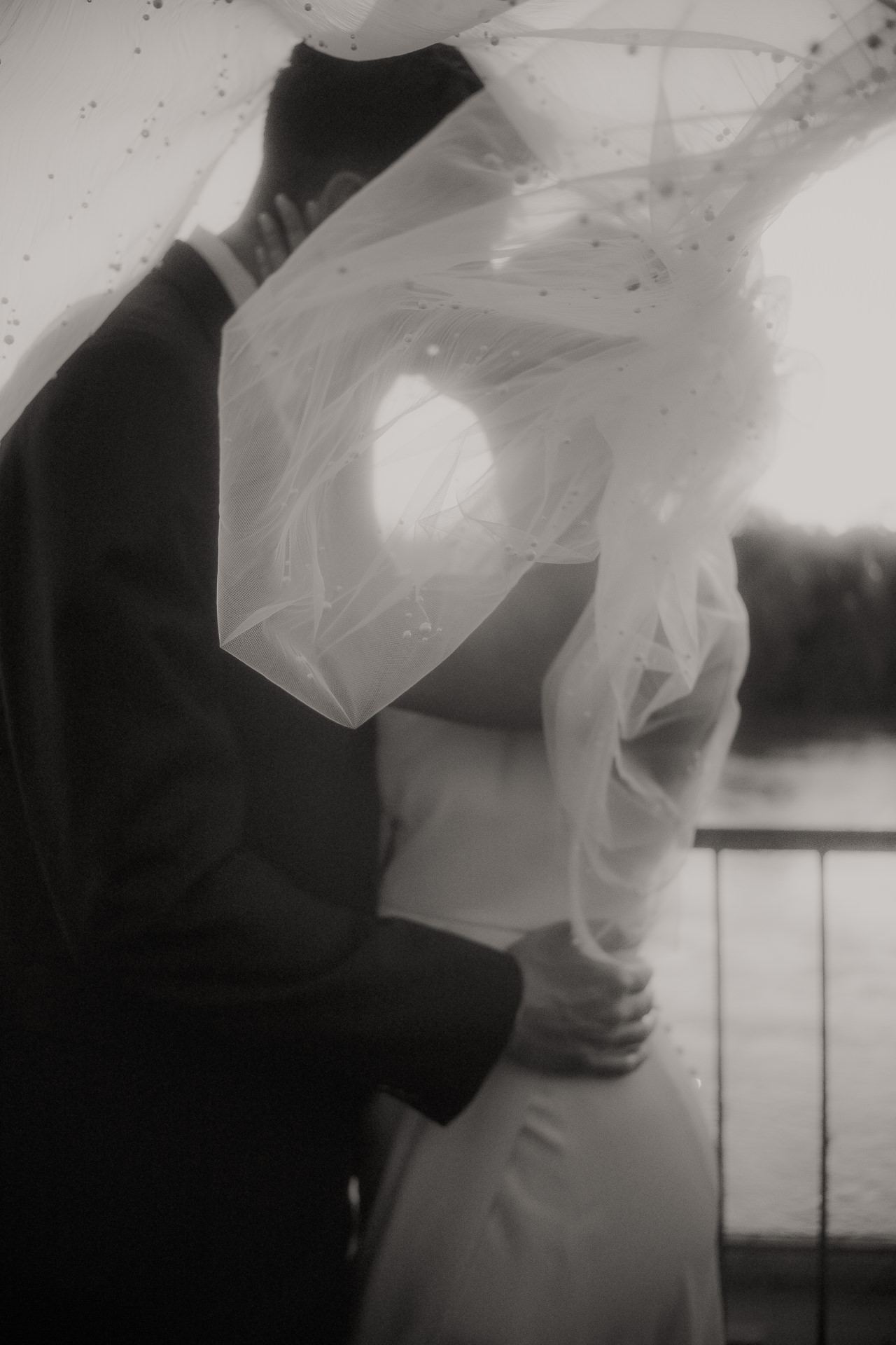 Black and white photograph of a bride and groom under her veil at a Revolution Hall wedding