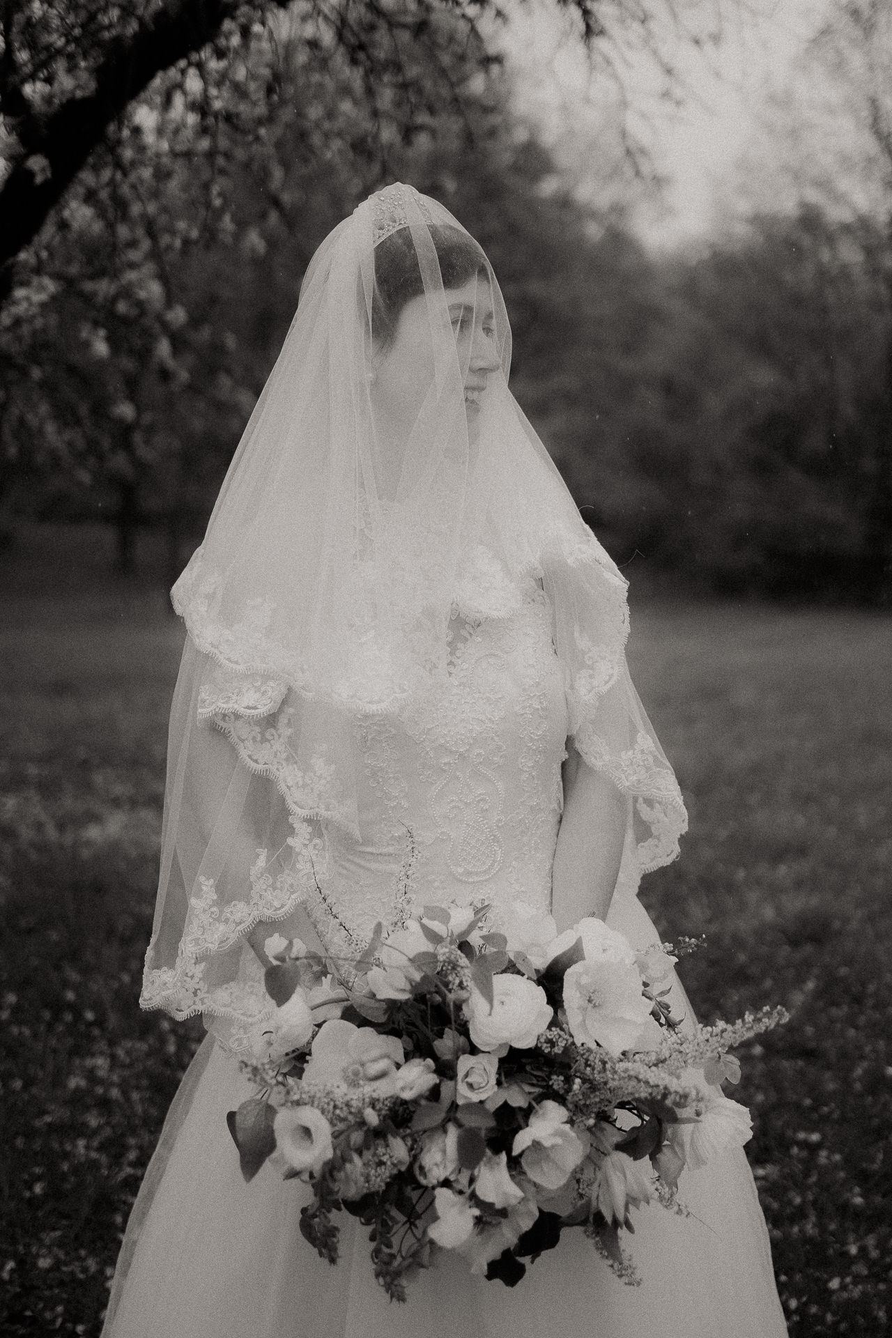 Black and white portrait of a veiled bride holding her bouquet at an Upstate New York wedding