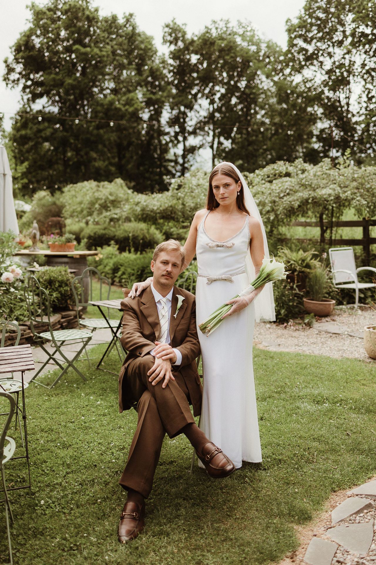 Bride and groom with a guest in the garden at a summer M and D Farm wedding