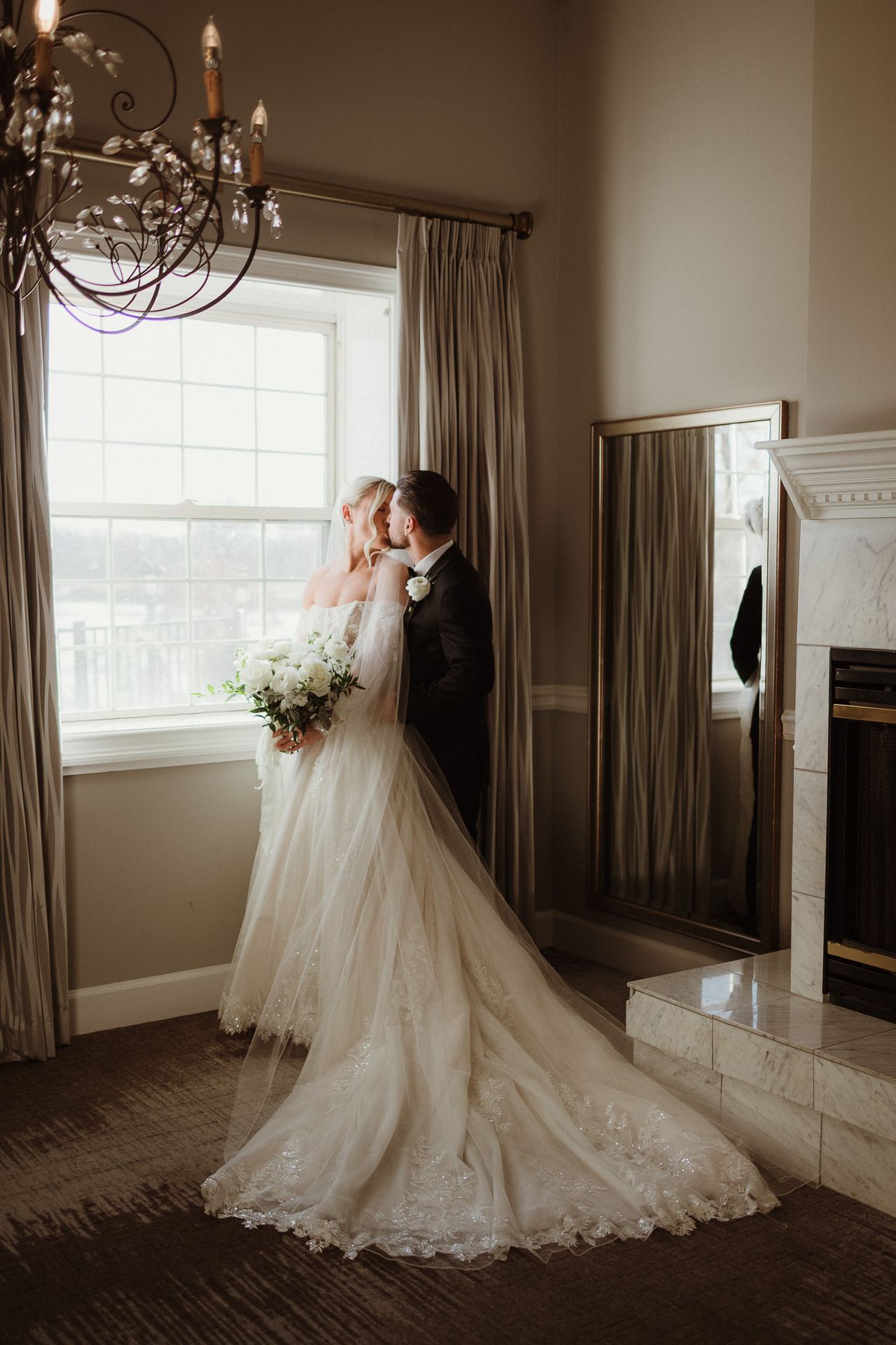 Bride in a sunlit hotel room holding her bouquet before a Glen Sanders Mansion wedding