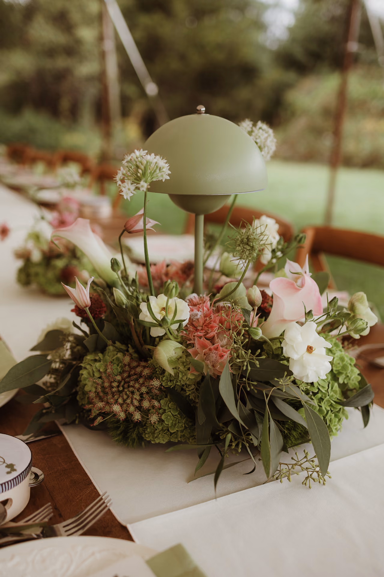 Garden-style floral centrepiece on a reception table at Windrift Hall