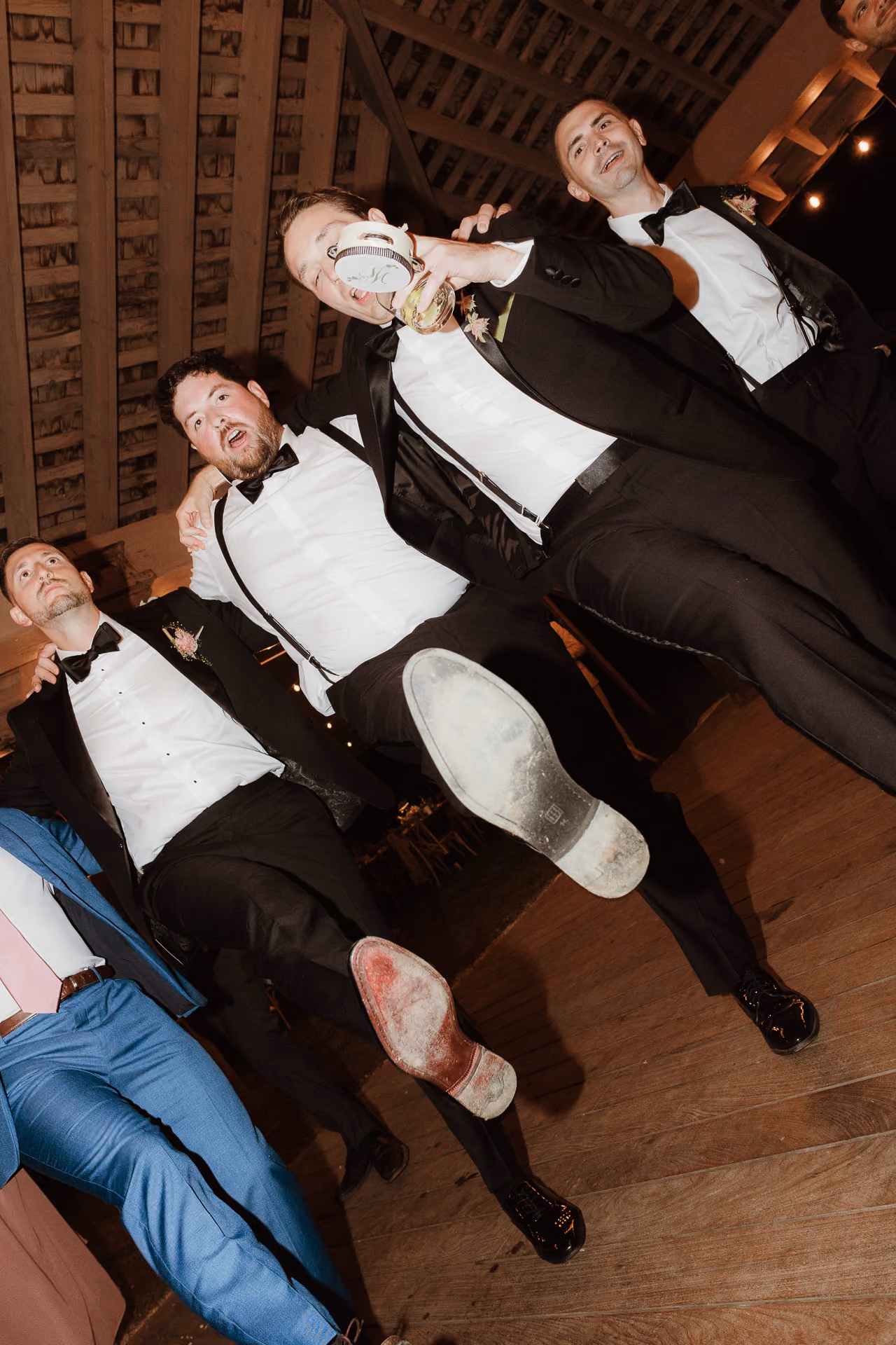 Groomsmen collapsing on the dance floor in tuxedos at Windrift Hall