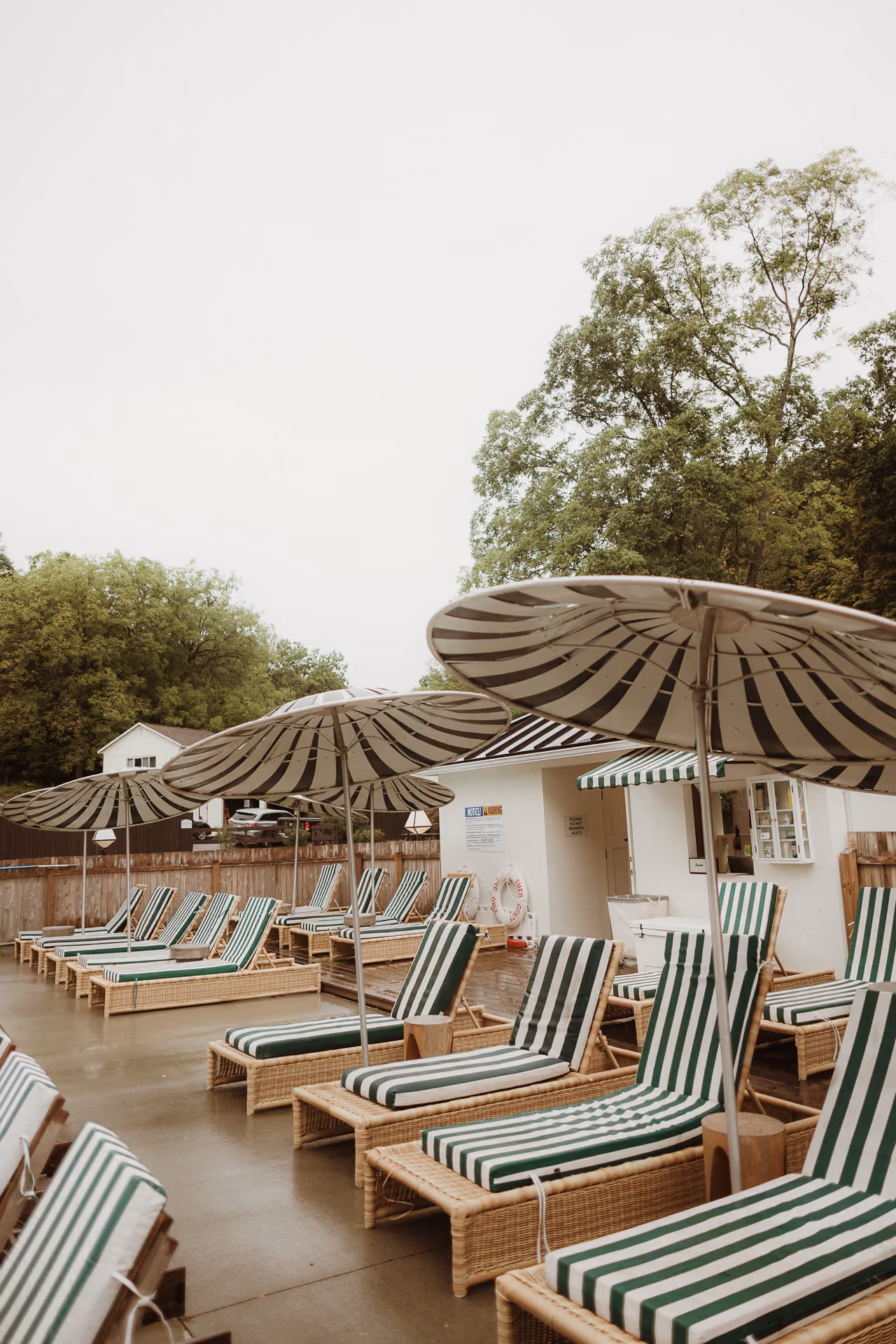 Striped umbrellas and lounge chairs around the pool at Camptown