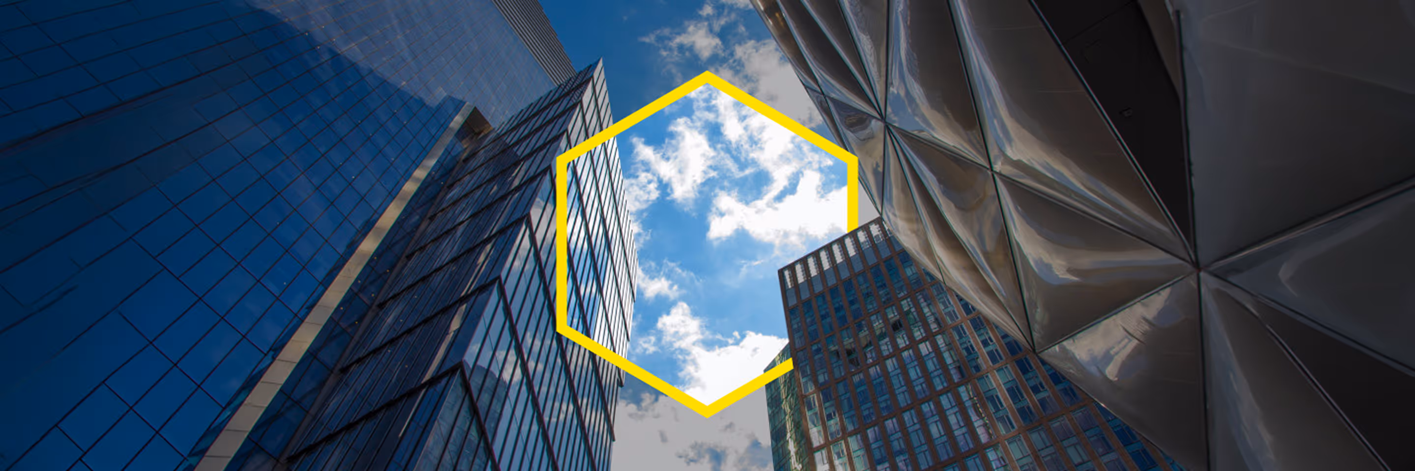 Upward view of modern skyscrapers with glass and metal facades under partly cloudy sky.
