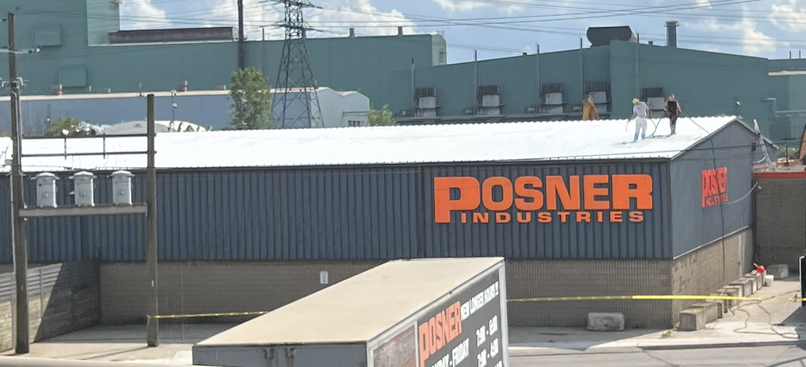 Posner industries' commercial building with Kemp Coating roofers applying a roofing system and coating