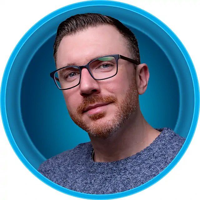 portrait of web designer kevin pauly, a man with glasses and a short red beard against a blue background