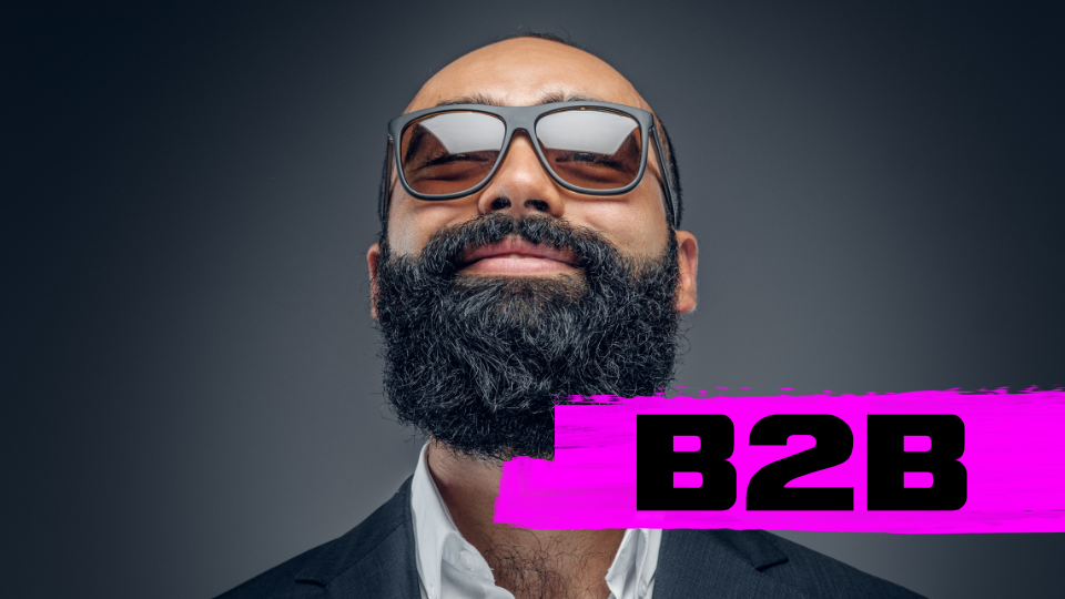 Smiling bearded man wearing sunglasses and a suit with a pink brushstroke overlay labeled 'B2B'.