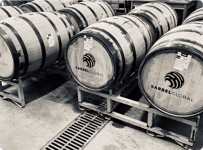 Rows of wooden barrels labeled Barrel Global stored on metal racks in a warehouse.