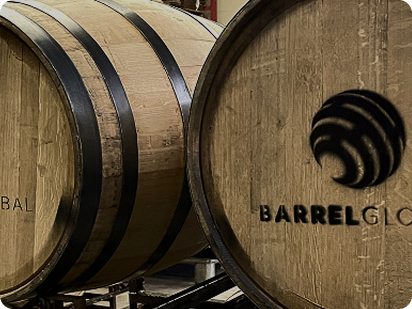 Close-up of wooden barrels, one labeled with the Barrel logo.