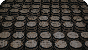 Rows of wooden barrels stacked closely, tops labeled with production details.
