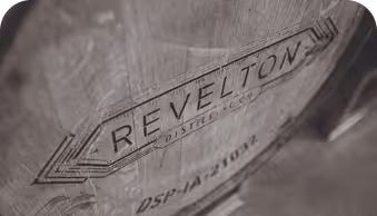 Wooden barrel with 'REVELTON DISTILLERY' stamped on its side in a vintage style.