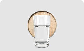 Glass of clear water sitting in front of a wooden coaster on a light gray background.