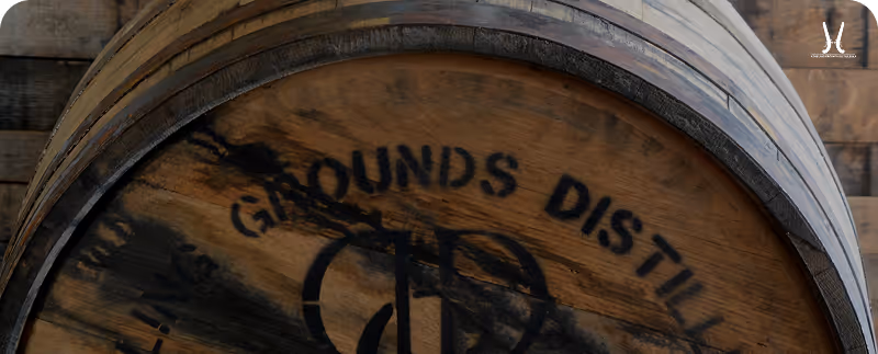 Close-up of a wooden barrel with faded black lettering and metal hoops.