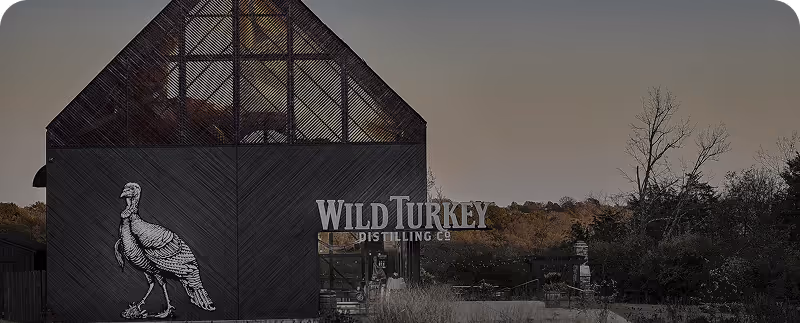 Distillery building with a wild turkey illustration and Wild Turkey Distilling Co. text at dusk.