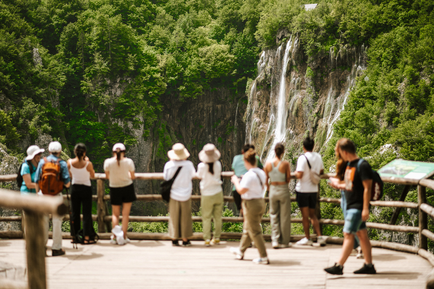 Tourists admiring the waterfalls of Plitvice Lakes