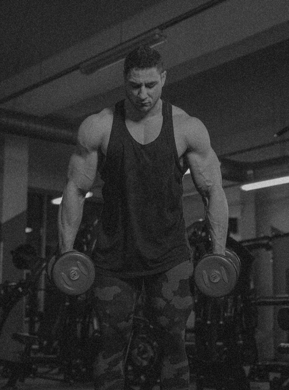 a men carrying dumbell in dark mode picture