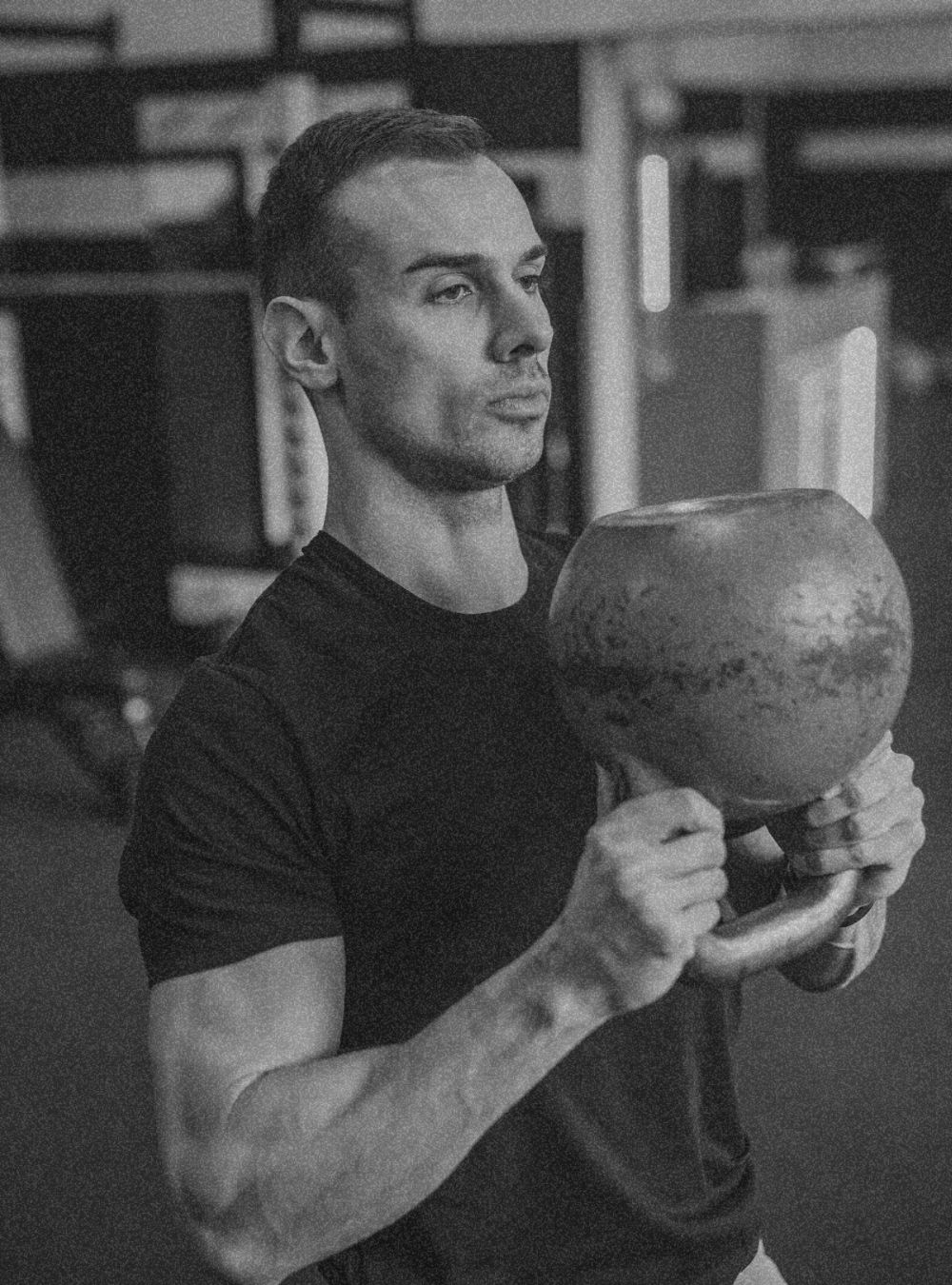 a man doing functional training with a kettlebell dark mode picture