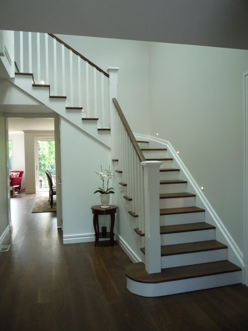 A classical timber staircase with painted risers and balusters. A rounded bottom step completes the look.