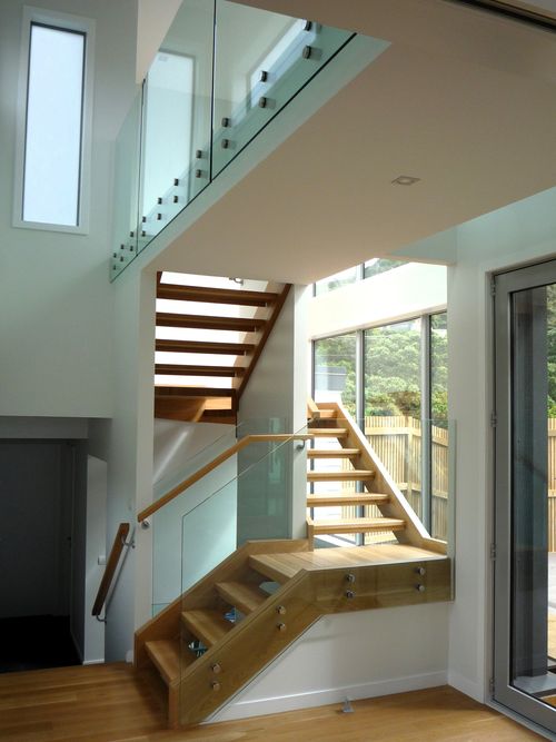 Separare timber stairs winding around central wall with glass balustrade
