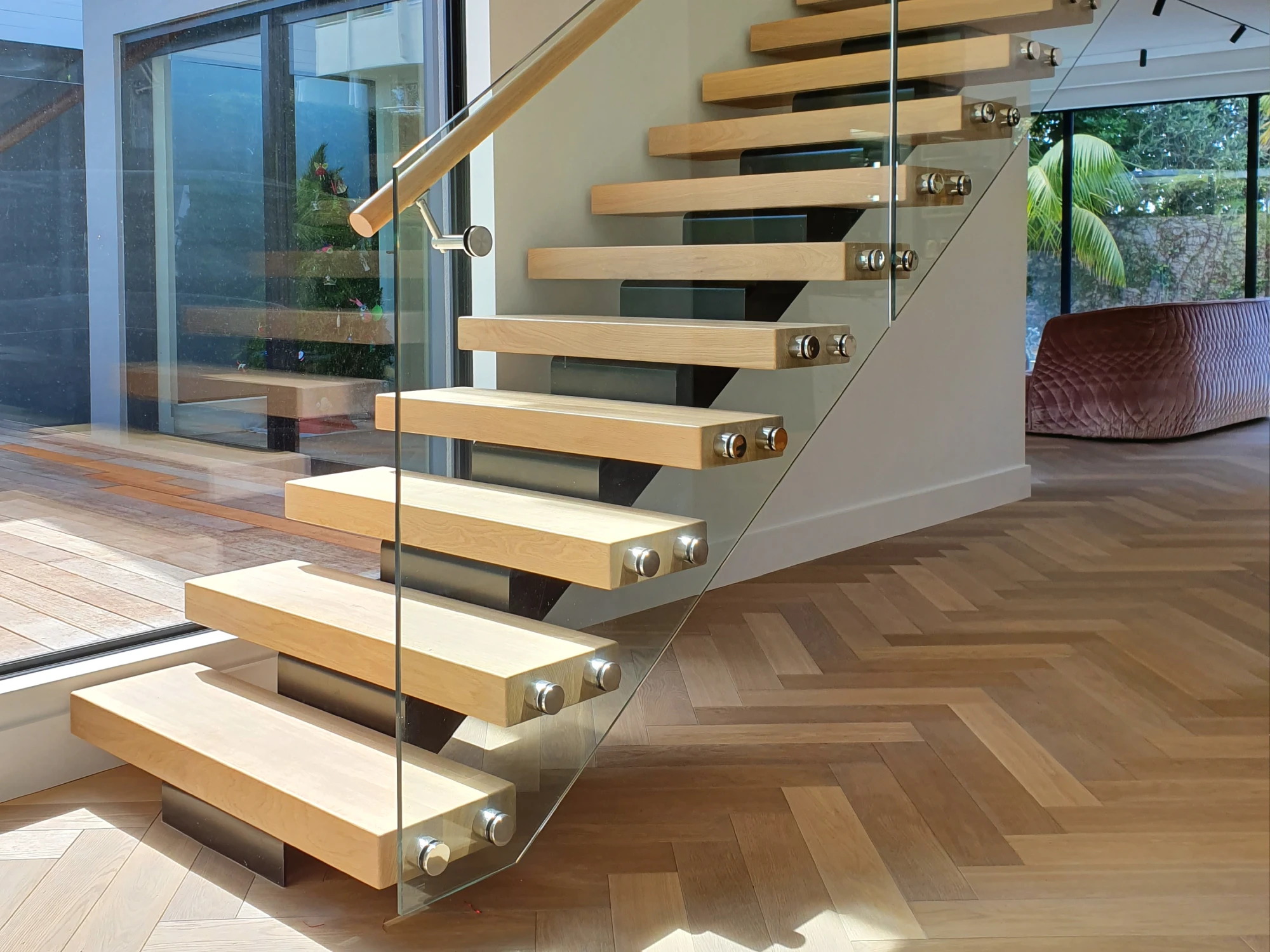 switchback timber floating stairs with glass balustrades in a minimalist home
