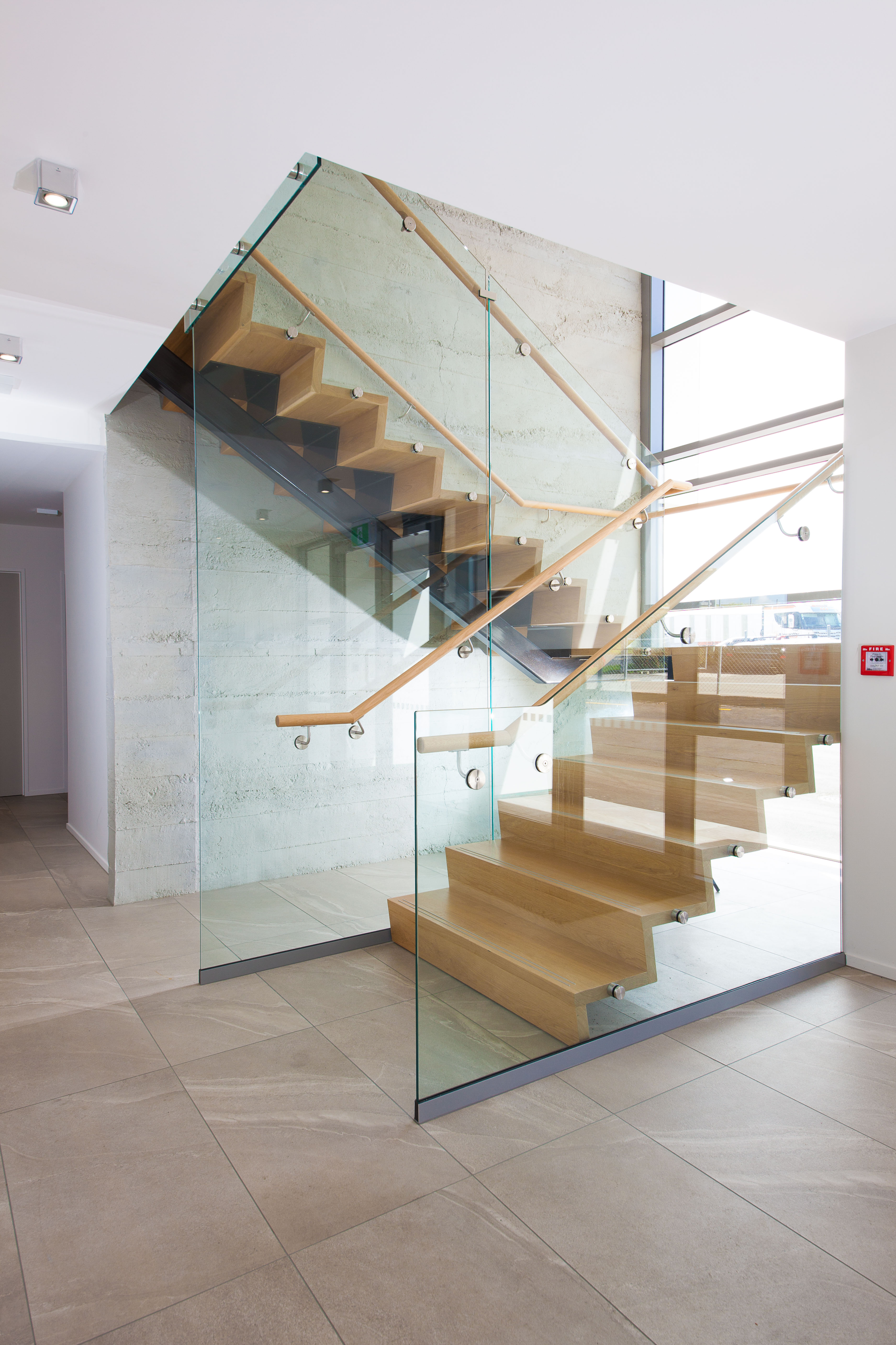 light timber floating stairs with glass balustrades and wooden railings
