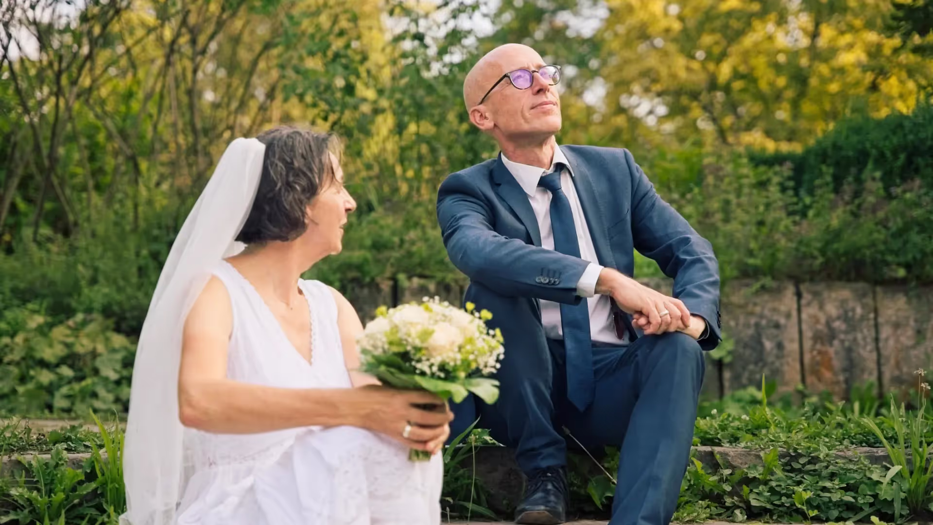 Bride and groom sitting on the ground