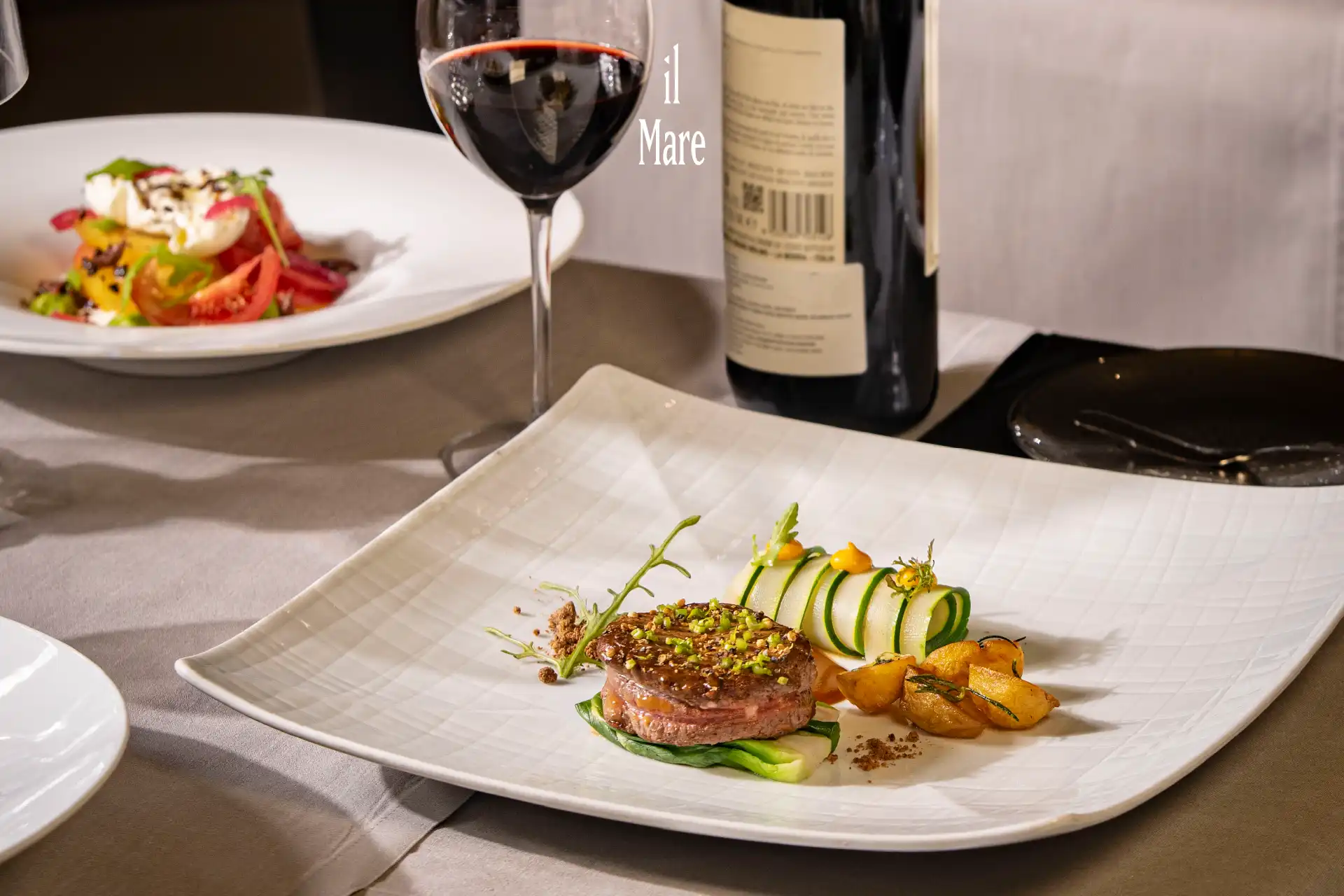 Executive Set Menu at il Mare featuring a plated three-course dinner with premium ingredients and wine in an elegant restaurant setting.
