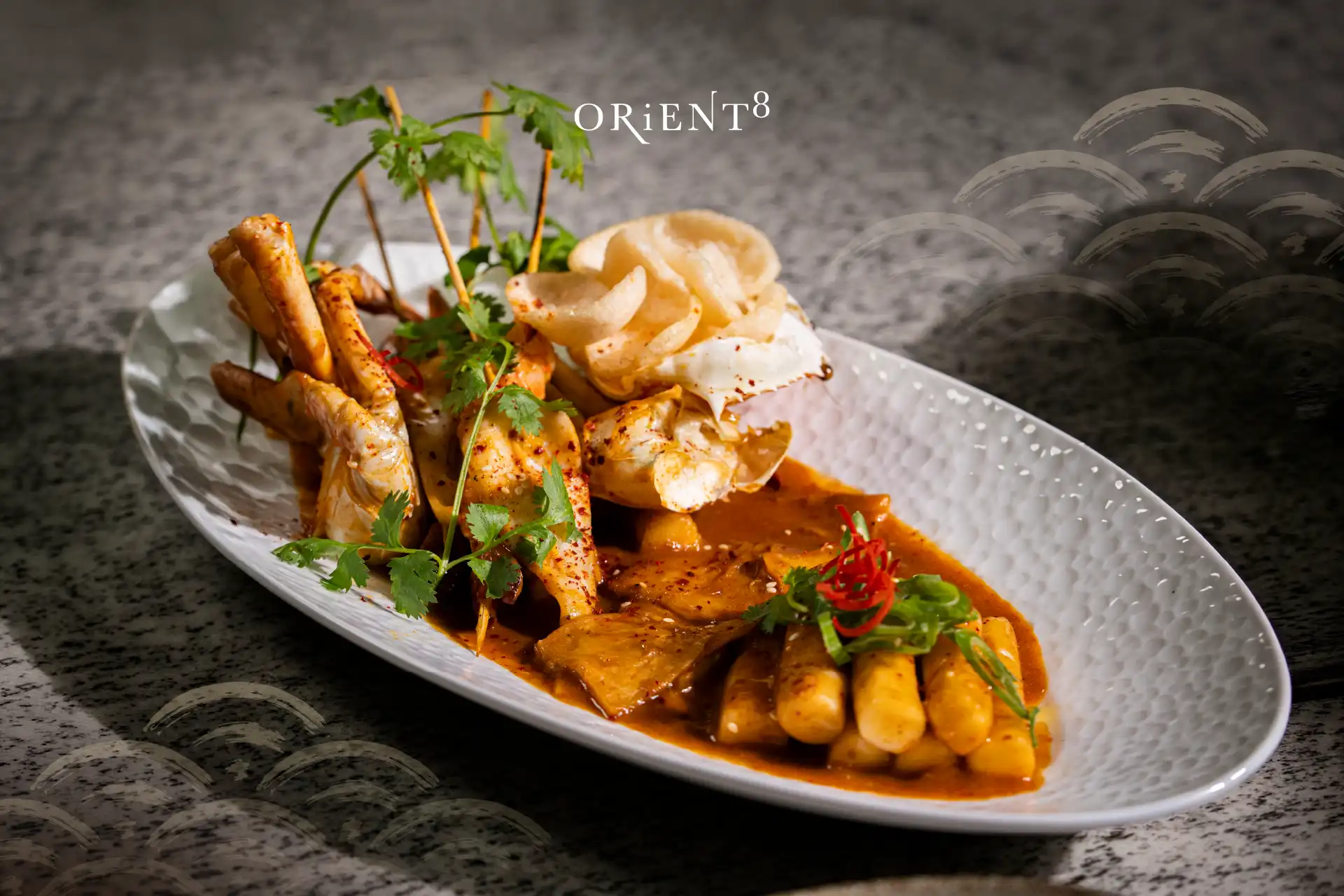 Orient8 Tteokbokki featuring Korean rice cakes served in a rich savoury sauce with assorted toppings and premium ingredients.
