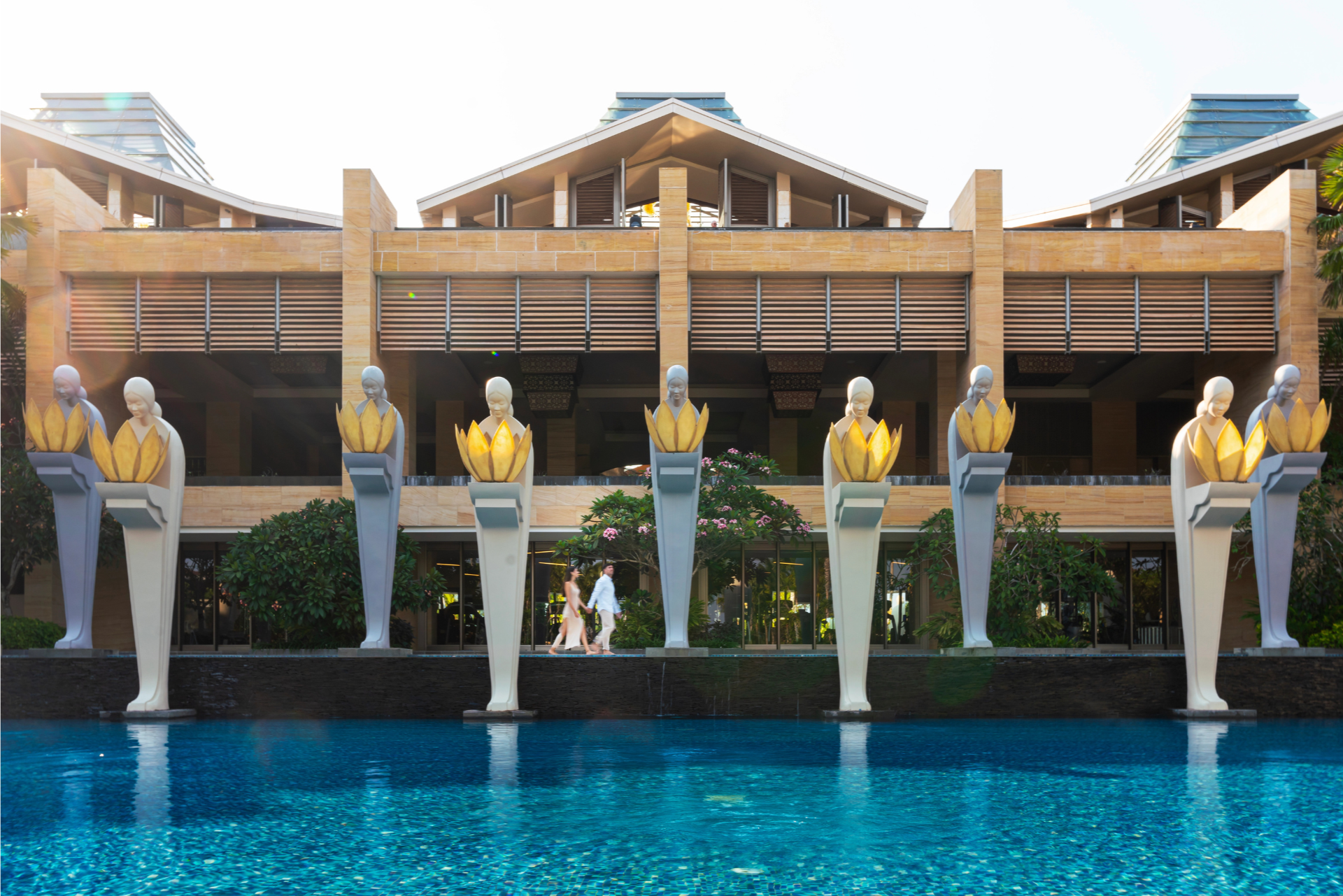Guests relaxing by the oceanfront pool before hotel check-in at The Mulia, Bali