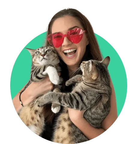 Woman in red shades smiling holding her two cats