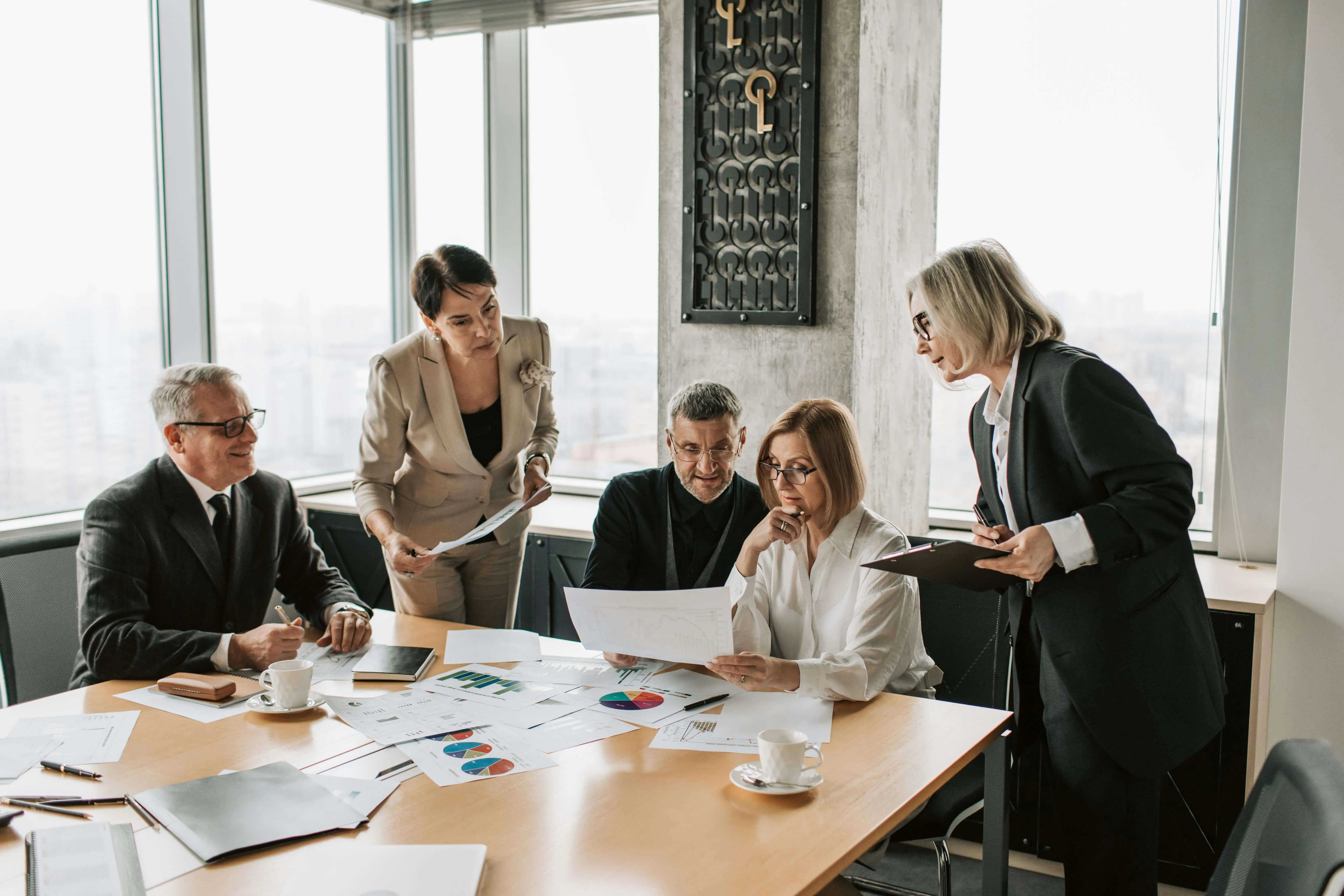 Team of five professionals discussing a project in a collaborative workplace