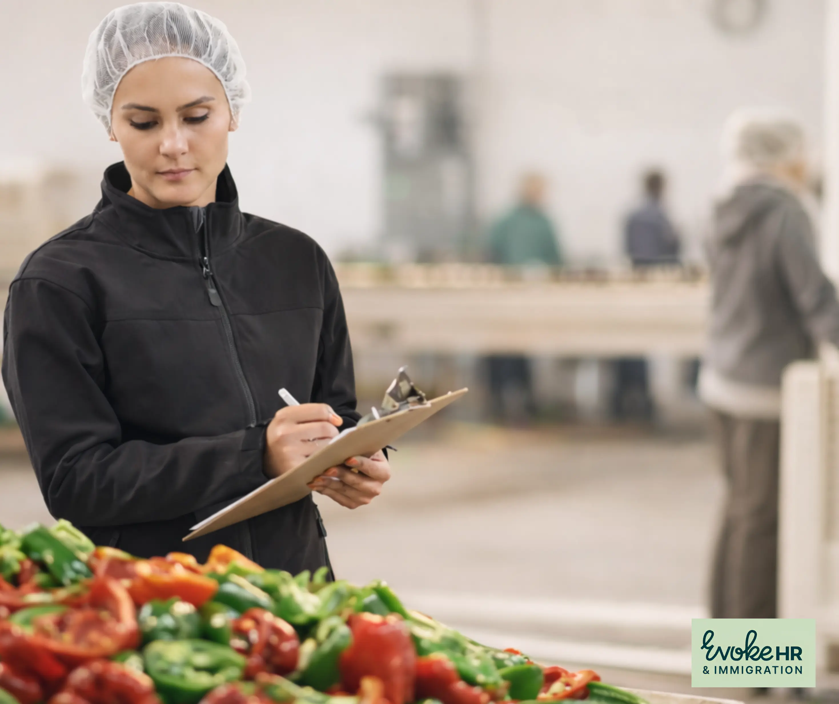 Woman with clipboard conducting workforce inspection in food processing facility