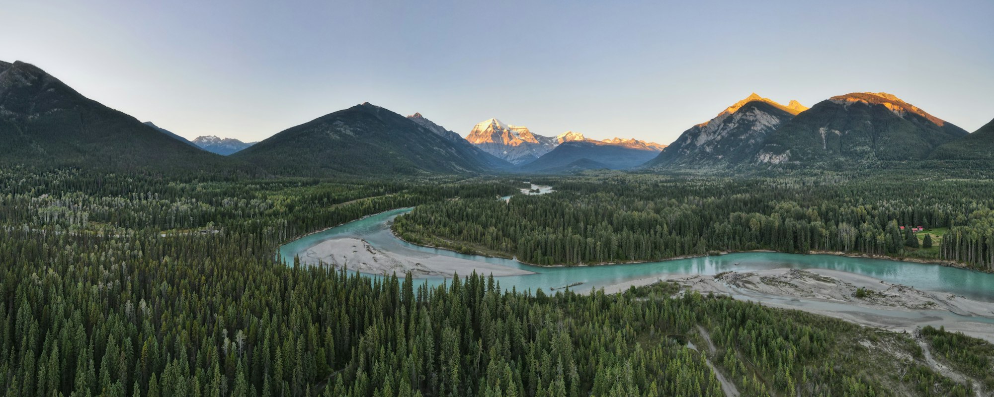 The Fraser River winding through forest below Mount Robson in British Columbia at sunset