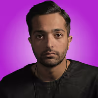 Portrait of a man with short dark hair and a trimmed beard, wearing a black shirt against a purple background.