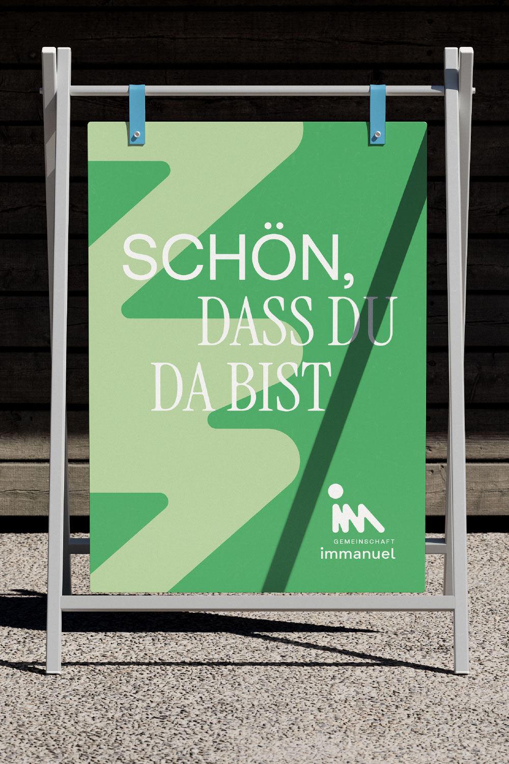 Grünleuchtendes Schild auf weißem Ständer mit Text Schön, dass du da bist und Gemeinschaft Immanuel Logo.