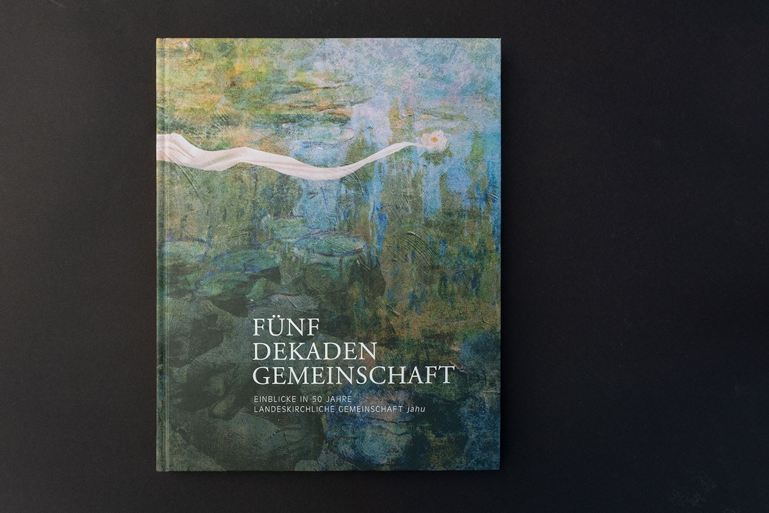 Buchcover mit abstraktem blauen und grünen Muster und Titel Fünf Dekaden Gemeinschaft.