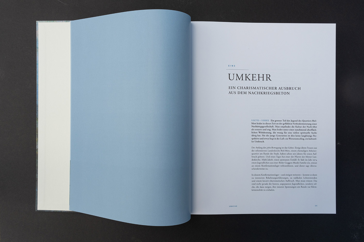 Offenes Buch auf schwarzem Untergrund, rechte Seite mit Überschrift und Text in deutscher Sprache.