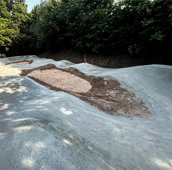 Pumptack with dirt and sand in a green area