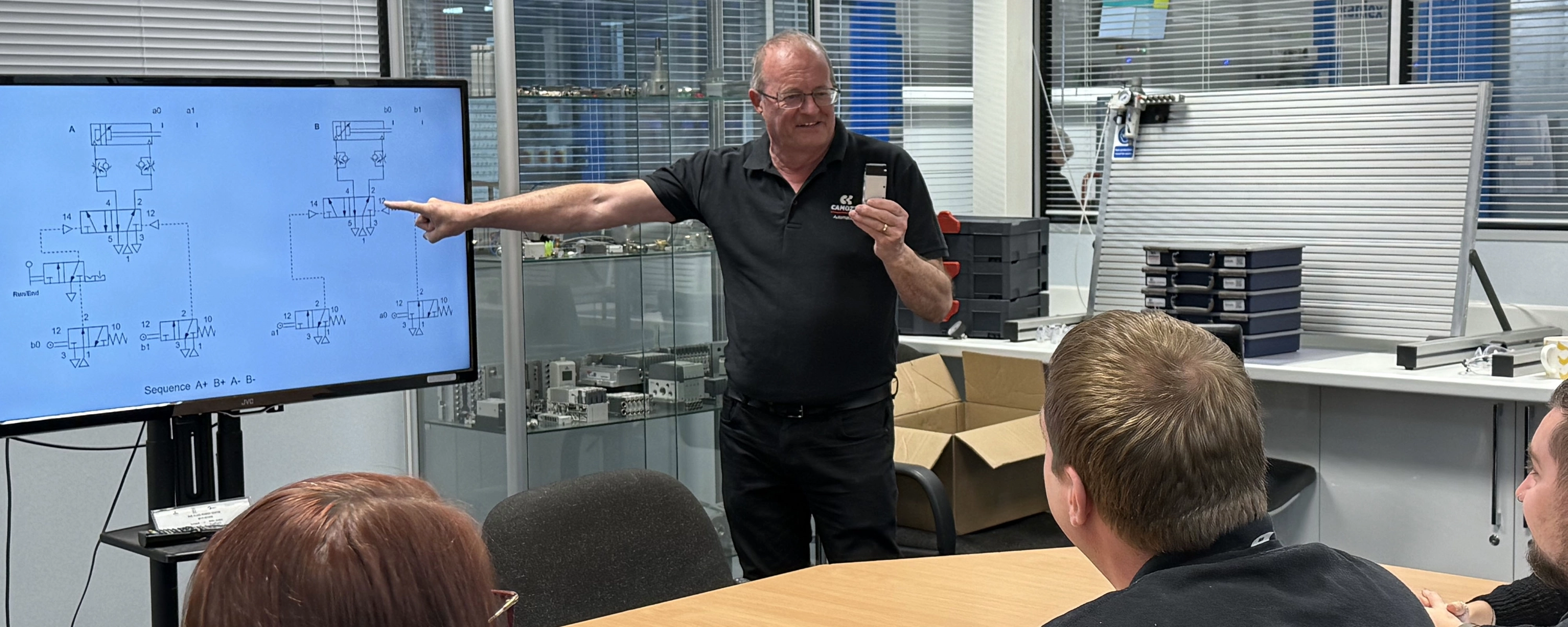 Expert course tutor Steve Partington explaining pneumatic circuit diagrams to a group of delegates during a classroom theory session at the Camozzi Automation UK.