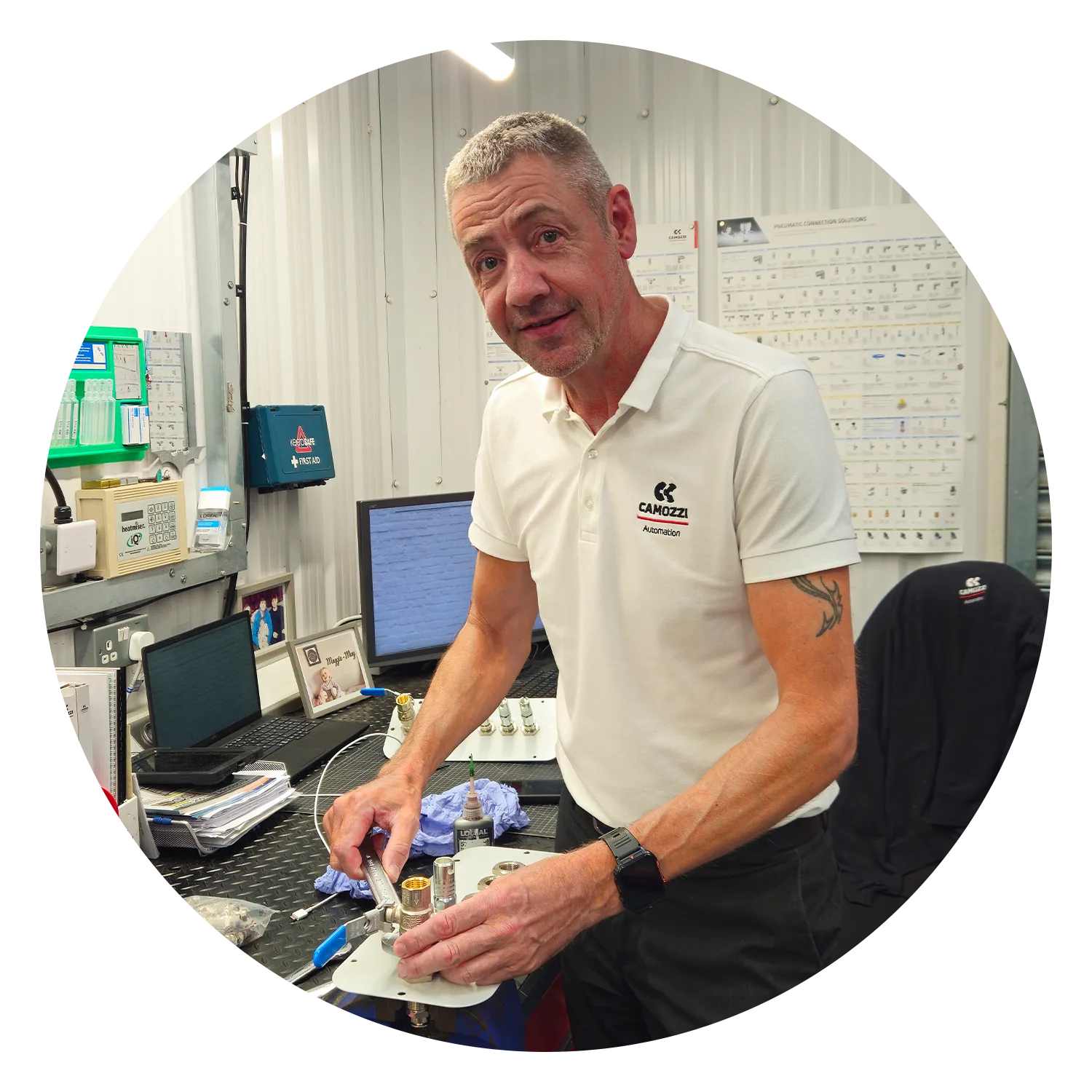 Stuart O'Reilly, Technical Support at Camozzi Automation UK, using a spanner to assemble pneumatic components at his workshop bench.