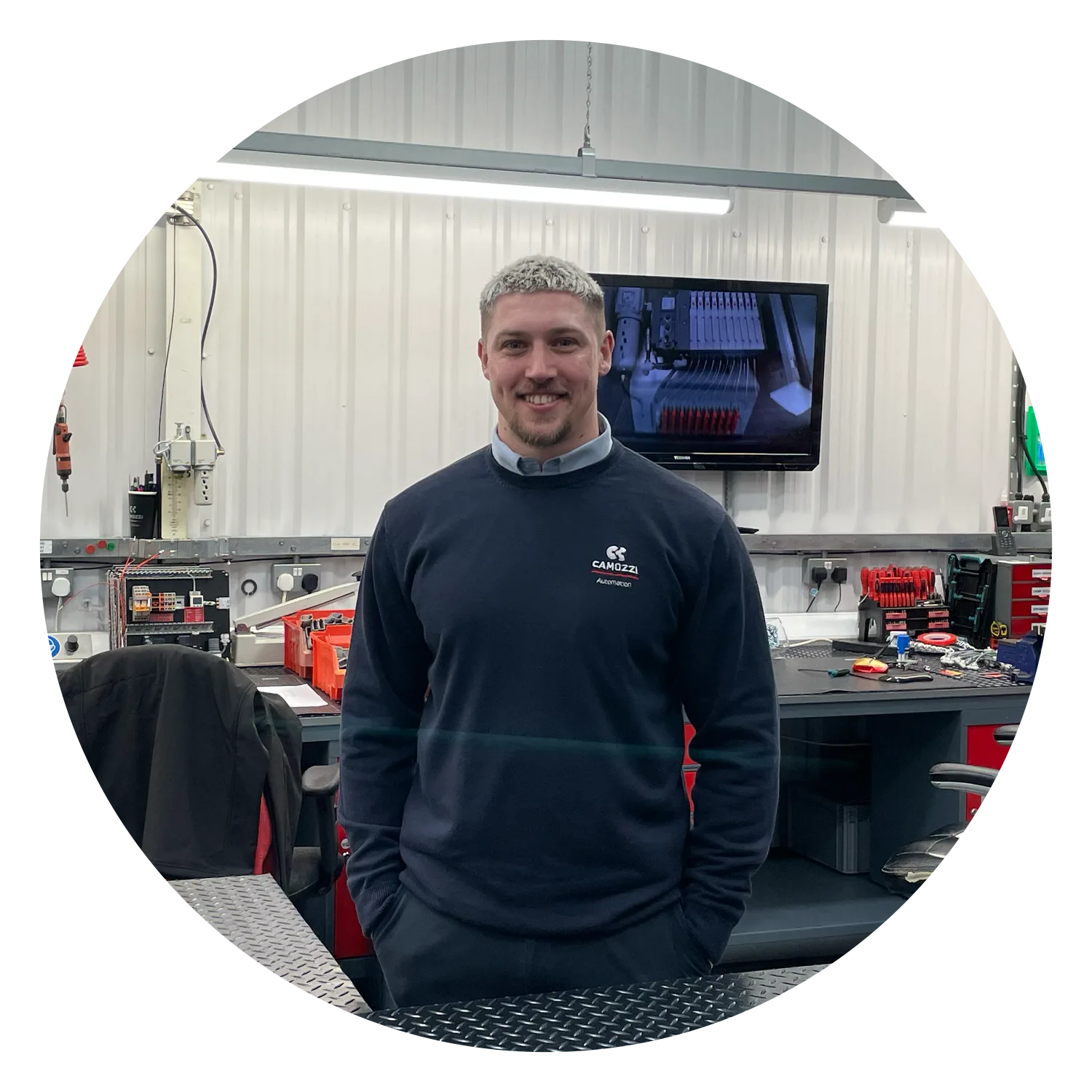 Tom Atkins, UK Applications & Automation Centre Manager at Camozzi Automation UK, smiling while standing in the UK Automation Centre workshop.