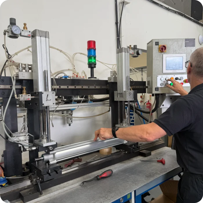 A Camozzi UK engineer using a specialised testing rig and control panel to conduct a rigorous leak test on a newly assembled pneumatic cylinder prior to rapid dispatch.