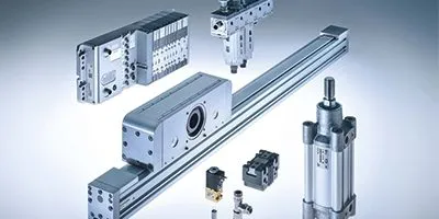 A collection of key Camozzi pneumatic system components, including an ISO cylinder, rodless cylinder, valve island, air preparation unit, and push-in fittings.