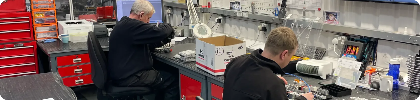 Camozzi UK engineers assembling bespoke pneumatic systems at their workbenches inside the Nuneaton Automation Centre workshop.