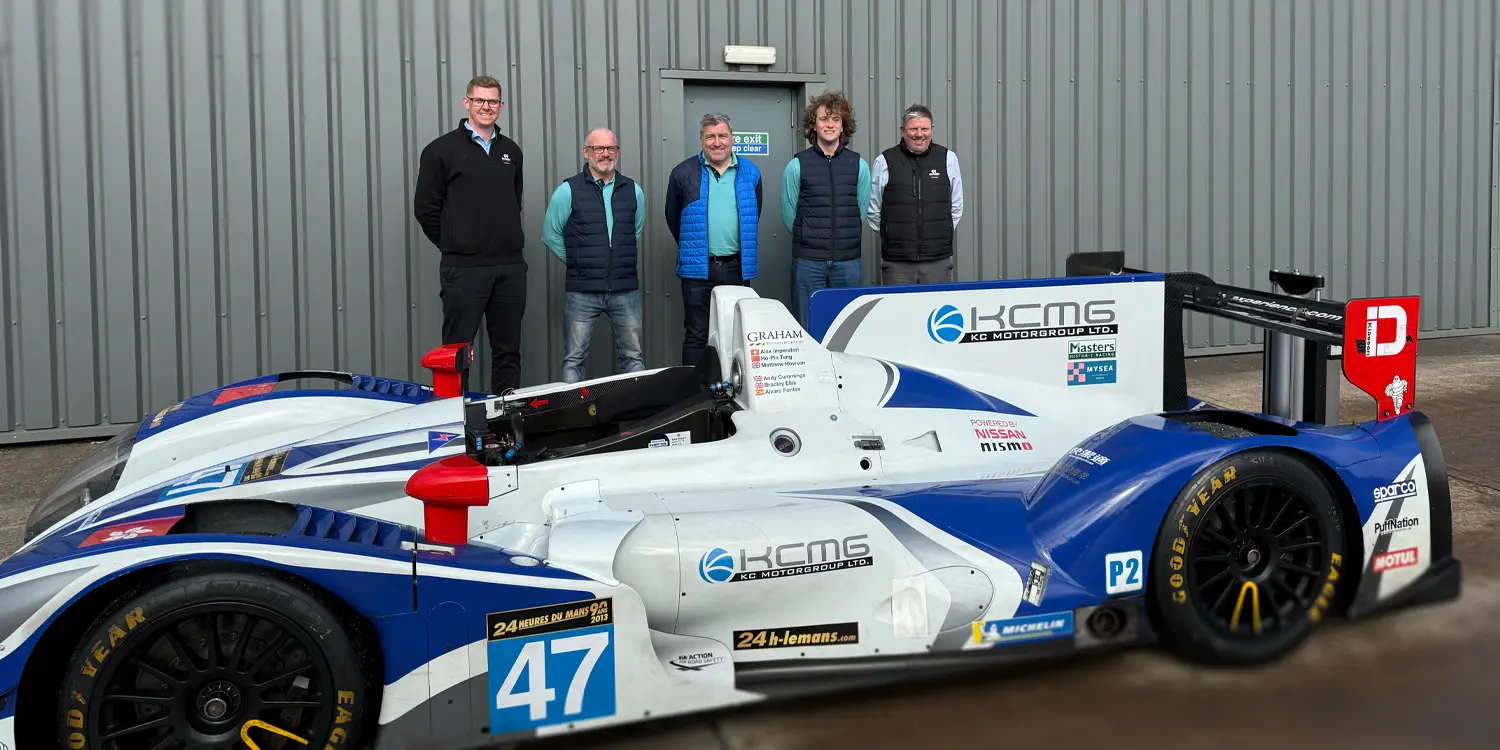 News thumbnail celebrating the motorsport partnership with JWA Engineering, featuring the engineering team standing proudly behind their Le Mans Classic race car.