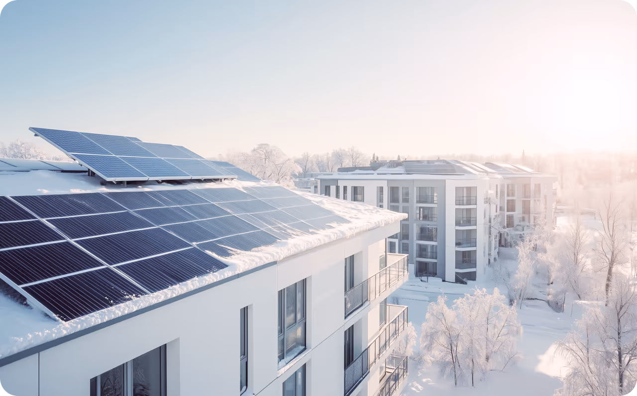 Solaranlage (PV) im Winter auf verschneiten Dächern von Mehrfamilienhäusern. Tipps für PV im Winter
