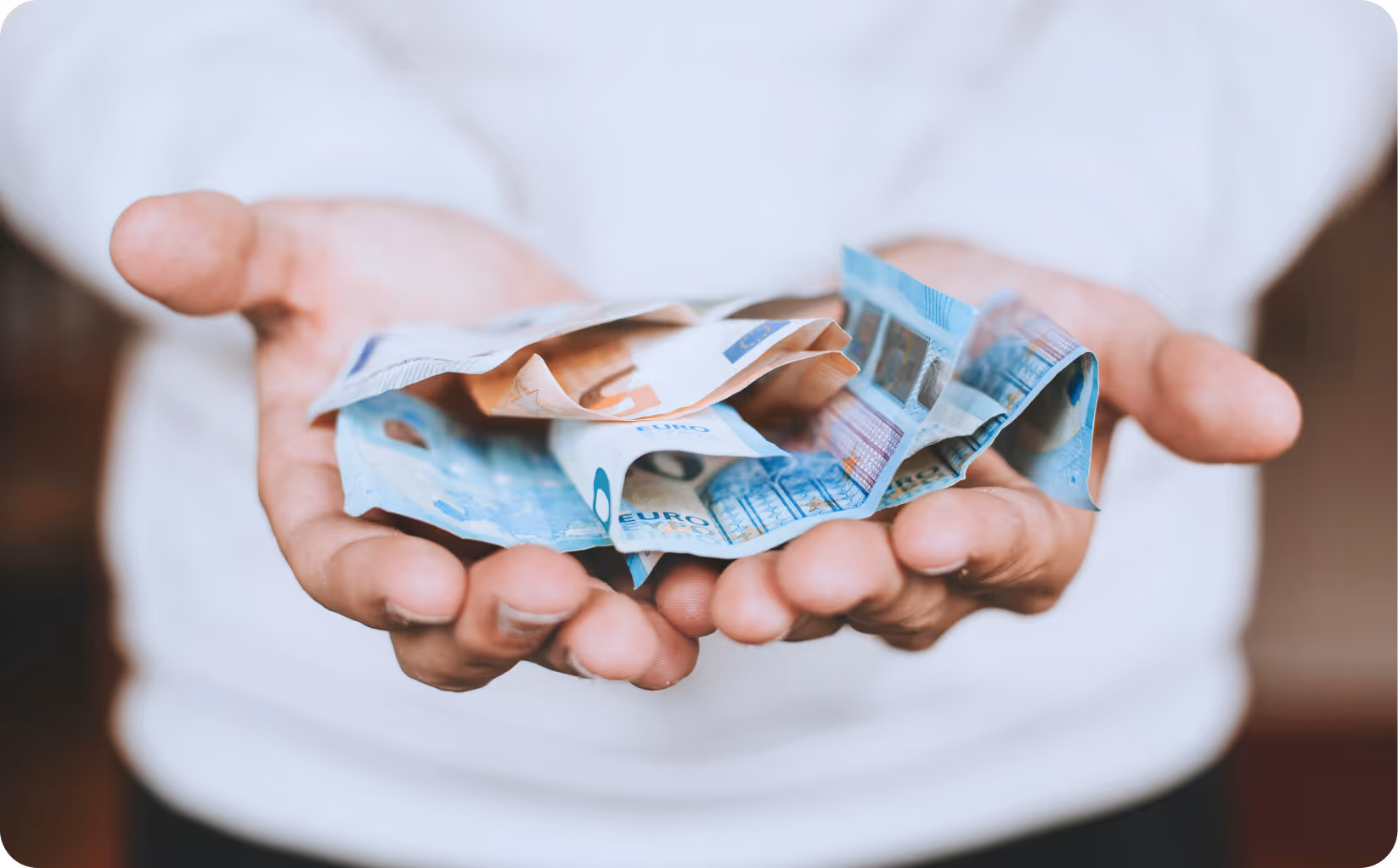 Geldscheine in den Händen (Symbolbild): Mit Stromspeichern und Mieterstrom können Sie viel Geld sparen und sogar gute Renditen erzielen! Mieterstrom von metergrid als große Chance