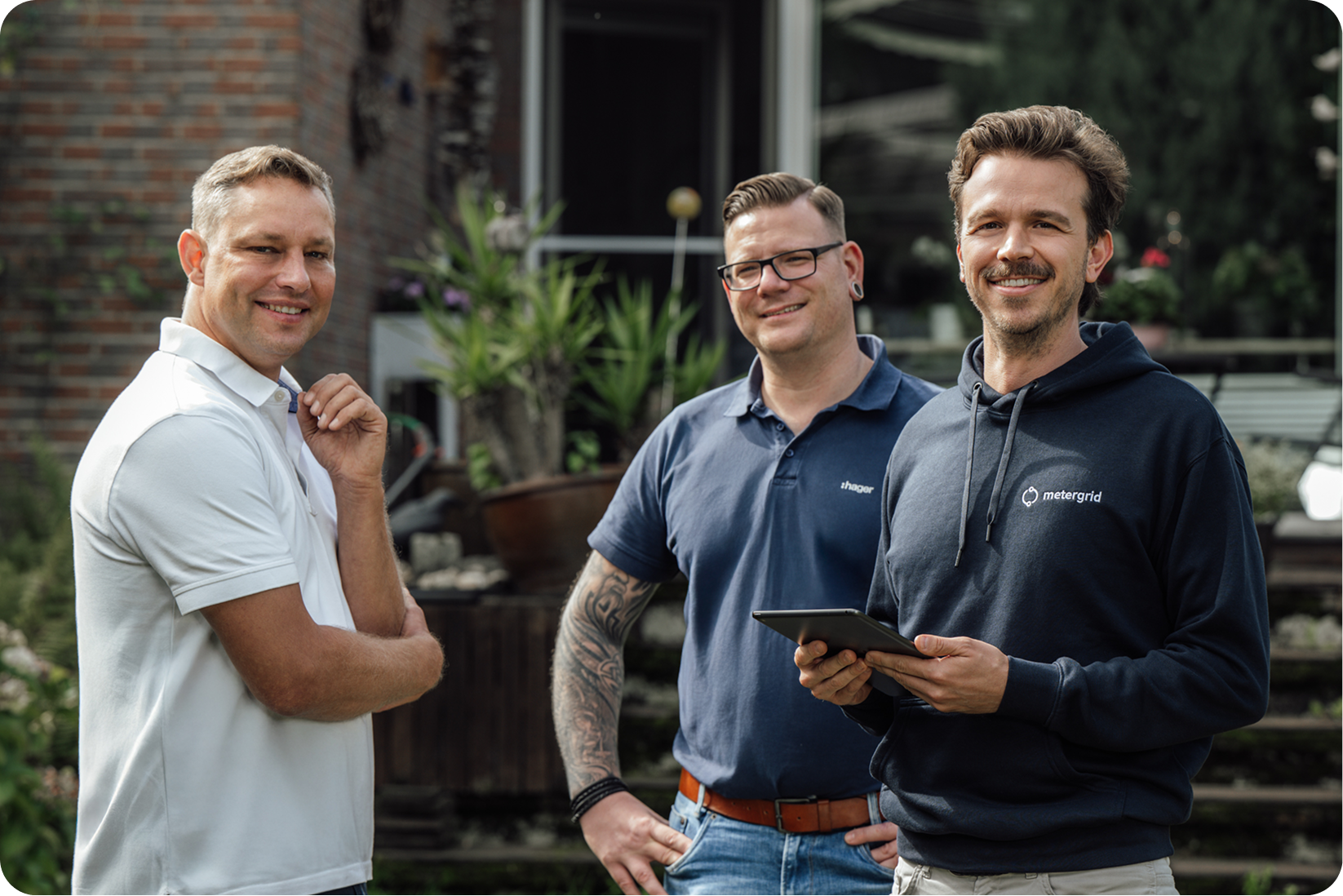 Projektbericht Mieterstrom in Neuss: Gruppenfoto Alan Atzberger von metergrid, Dominik Prahl von Hager und Mieterstrom-Kunde Heiko van Bergen